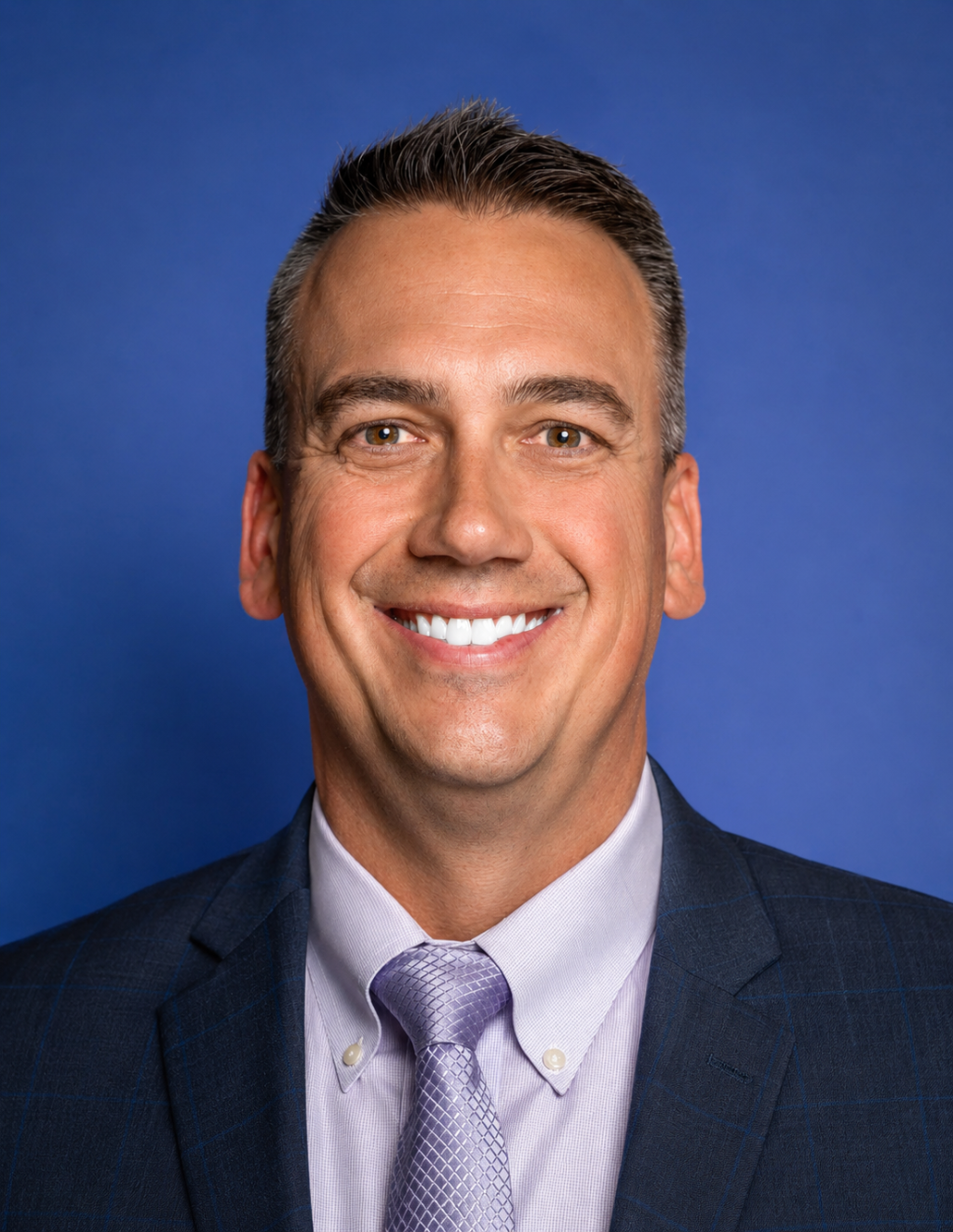 Man with short cropped hair smiling at camera